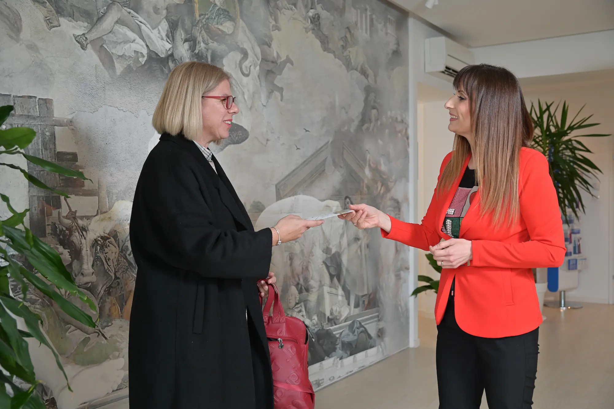 Paziente accolta nella reception di Dental Professionals durante il primo arrivo in clinica.